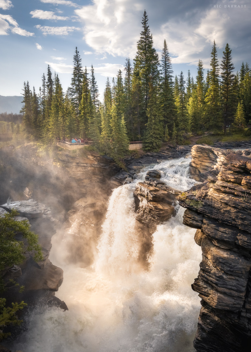 Thunderous waterfall cascading over a cliff in Canadian forest land.