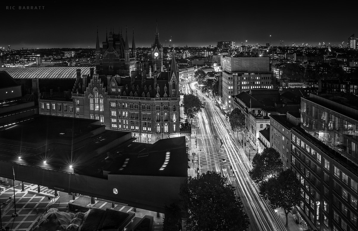 Long exposure of car headlight trails travelling along busy Euston Road at night.