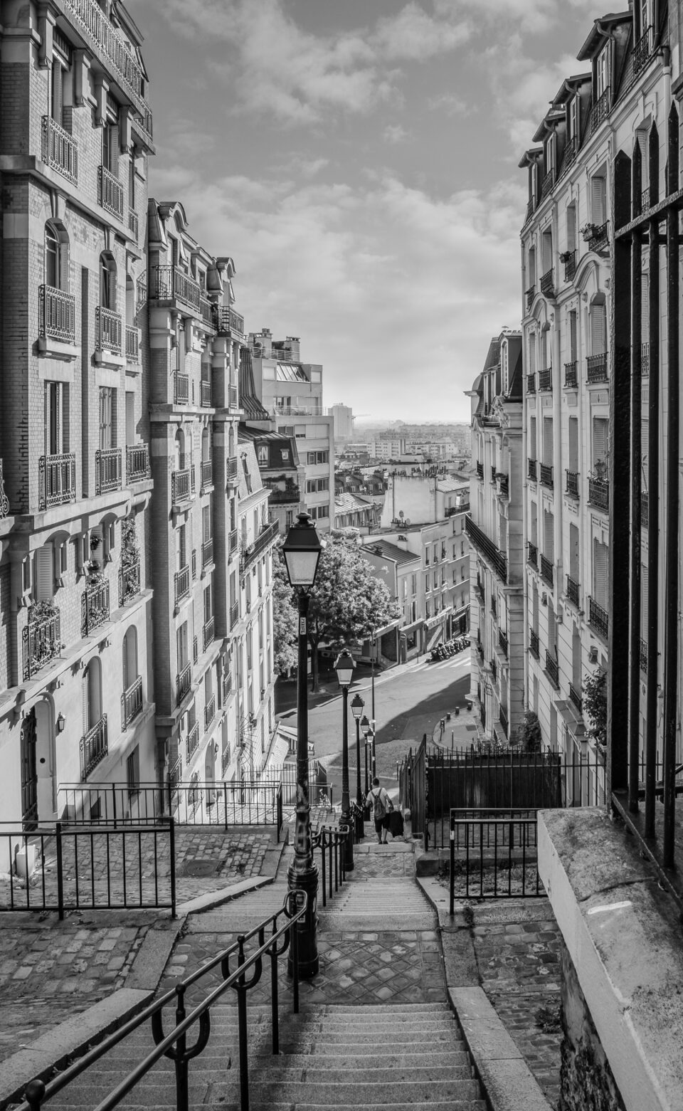 Long stairway leading down between tall Parisian buildings.