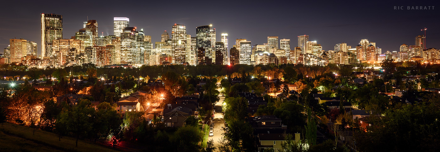 Dazzling skyscrapers of downtown Calgary reaching into dark night sky.