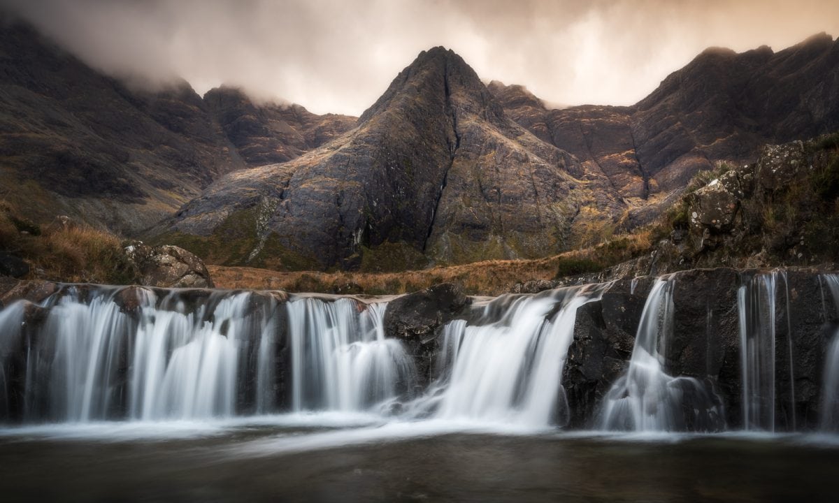 Waterfalls near to steep mountain slopes.