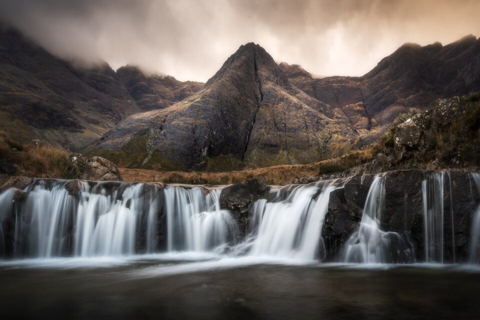 Waterfalls near to steep mountain slopes.