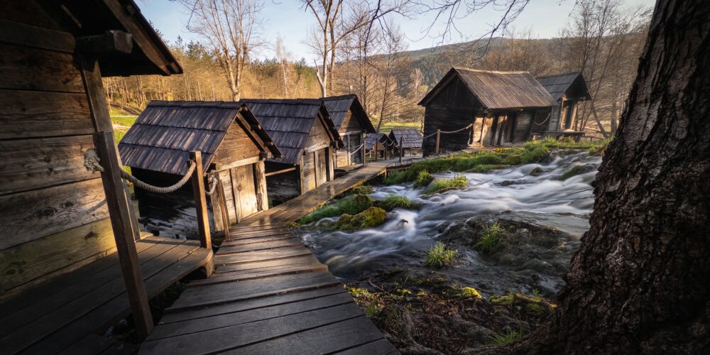 Historic watermills along a flowing river in Mlinići Watermills, Bosnia and Herzegovina.