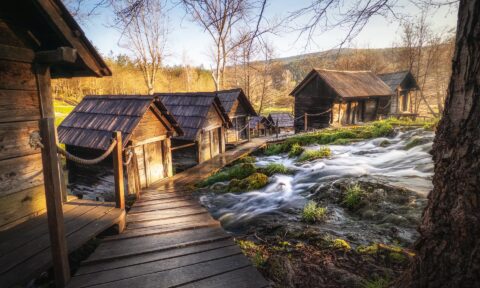 Historic watermills along Mlinići River with flowing water and wooden structures.