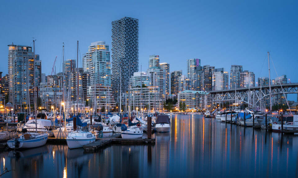 Downtown Vancouver skyline with marina and boats at dusk.