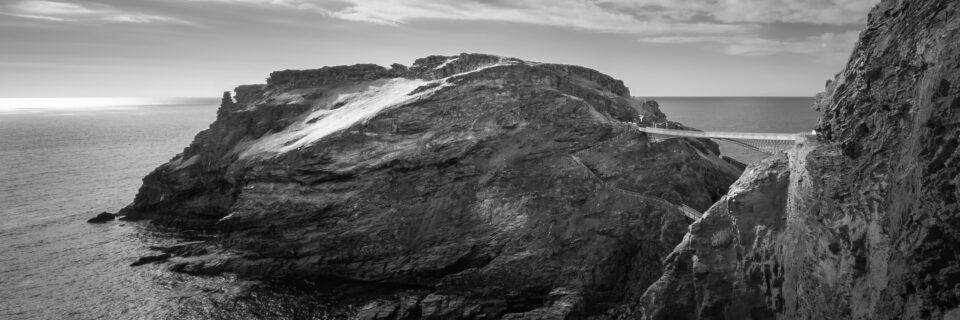 Black and white photo of Tintagel Castle cliffs and coastline.